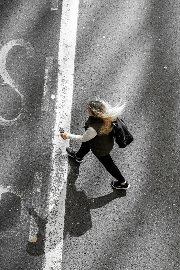 Woman walking to The Foot Spot in Kansas City to find a pair of comfortable shoes that relieve her foot pain. 