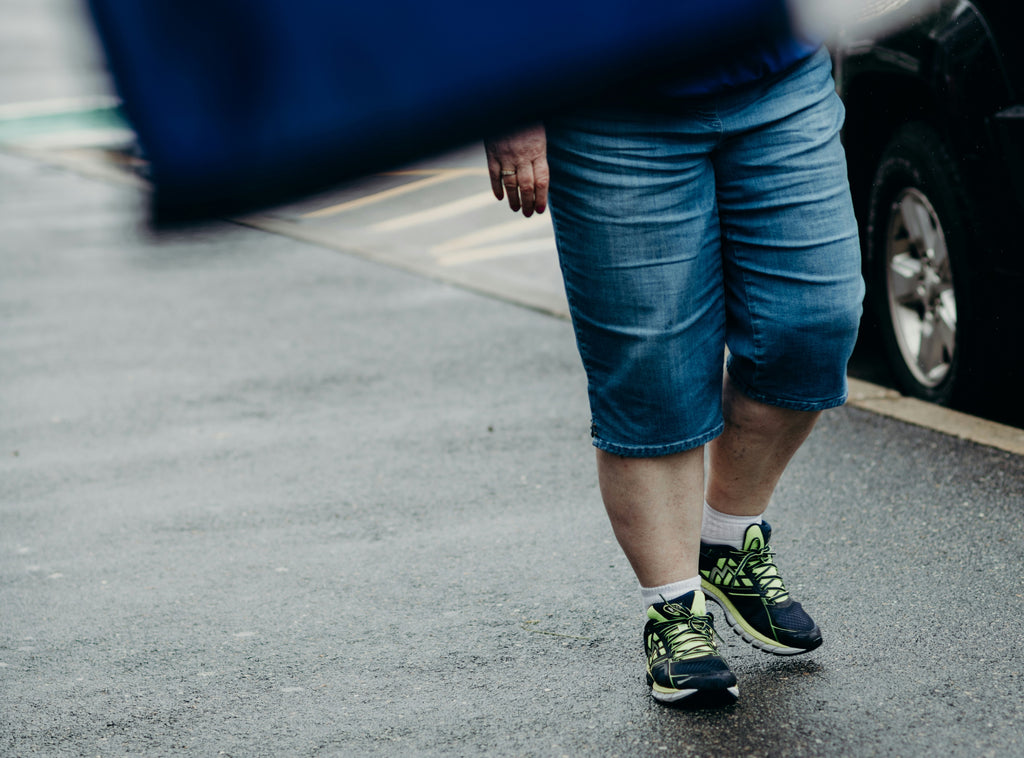 Woman walking towards The Foot Spot in Kansas City to find a solution for her bunions. The free foot and gait assessment will guide her towards a life with less pain and better foot health.